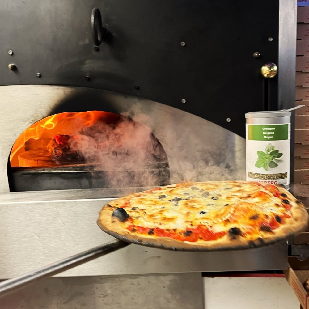 Pizza sortant du four dans le food truck Pizza Délice