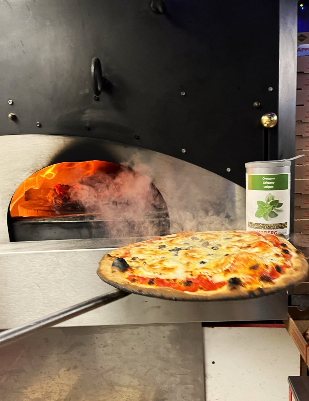 Pizza sortant du four dans le food truck Pizza Délice